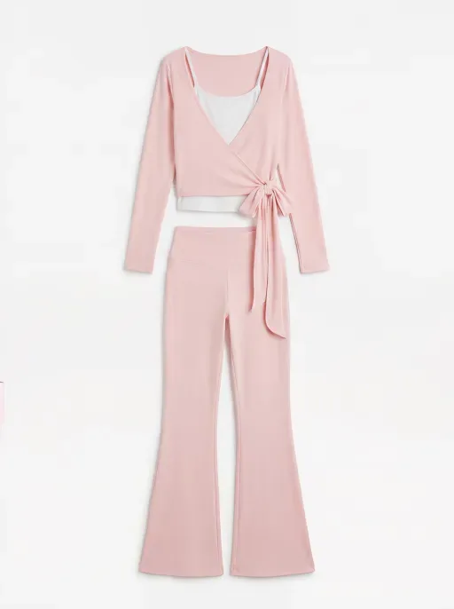 Foto im Flat-Lay-Stil: Ein pinkfarbenes, geripptes Wickeloberteil mit weißem Unteroberteil und passender Schlaghose.