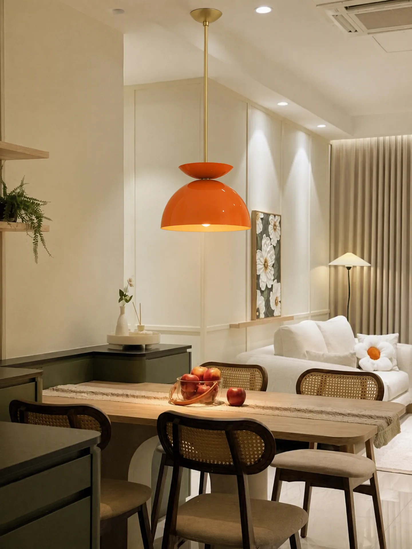 Orange pendant lamp installed, illuminated, and integrated into the existing dining-room scene