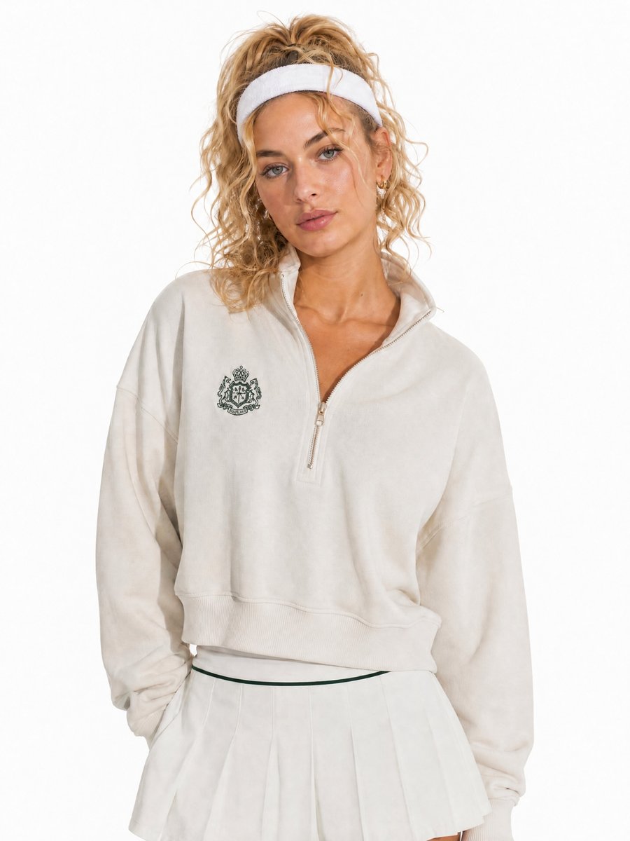 AI-generated model reference photo of a woman with curly blonde hair in a cream half-zip sweatshirt and a white headband