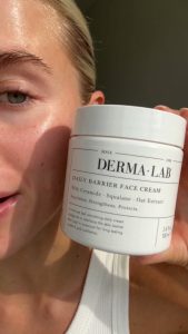 Final frame from the AI-generated moisturizer UGC video showing a woman holding the jar beside her face